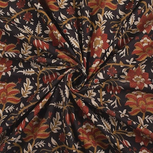 Op de afbeelding: Close-up van een donkere stof met een bloemenpatroon. Het ontwerp toont grote rode en gouden bloemen, crèmekleurige bladeren en dunne gouden ranken tegen een zwarte achtergrond. De stof is geplooid en toont zijn textuur.