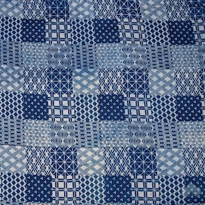 Może przedstawiać: Niebieska i biała tkanina z powtarzającym się geometrycznym wzorem. Tkanina składa się z kwadratów z różnymi wzorami, w tym gwiazdami, rombami i kółkami.