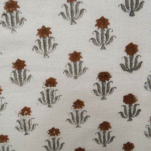 Grey White floral hand block print cotton fabric featuring traditional Indian artisan craftsmanship on soft lightweight cotton. This handmade Jaipur block printed fabric is shown in a swirl drape to highlight its smooth texture, natural flow, and elegant floral motif. Perfect for dressmaking, quilting, sewing, kurtas, summer dresses, blouses, home décor, DIY crafts, and fabric by the yard projects. 
 
block print fabric, fabric by the yards, cotton fabric, hand dyed fabric, Indian cotton fabric