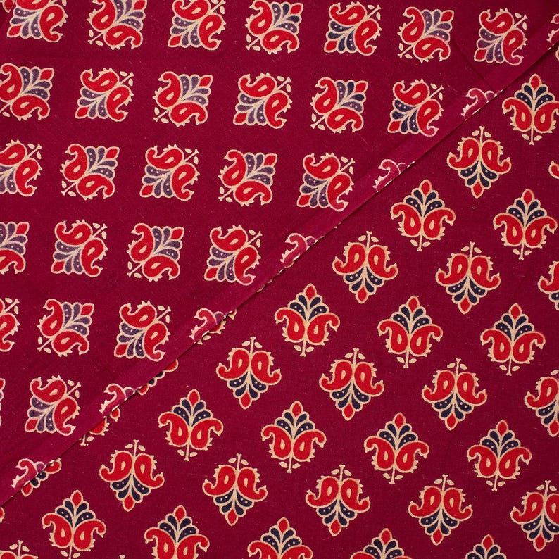 Hand block printed 100% cotton fabric featuring a traditional Indian floral pattern with intricate artisan detailing. Soft, breathable, lightweight fabric sold by the yard, ideal for sewing dresses, blouses, skirts, quilting, patchwork, home décor, cushion covers, curtains, table linens, tote bags, and a variety of DIY craft projects. Perfect for fashion designers, crafters, and handmade creations.
