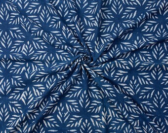 Pode incluir: Tecido azul com um padrão de folhas brancas. O tecido está dobrado e tem uma superfície texturizada.