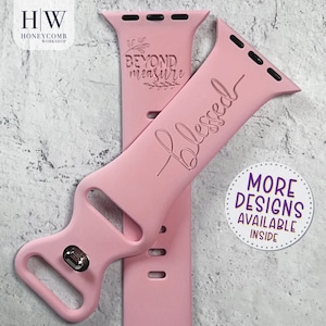 May include: Pink silicone Apple Watch band with the words "Beyond Measure" and "Blessed" engraved on it.