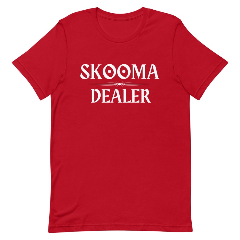 May include: Red t-shirt with white text that reads "SKOOMA DEALER" with a stylized design above the word "DEALER".