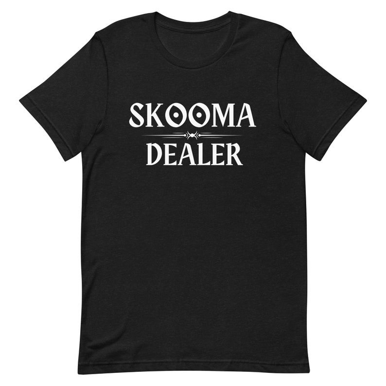 May include: Black t-shirt with white text that reads "SKOOMA DEALER" with a stylized design above the word "DEALER".