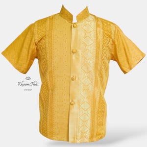 May include: A gold short-sleeved shirt with a mandarin collar and a button-up front. The shirt has a patterned design with a vertical stripe down the centre.