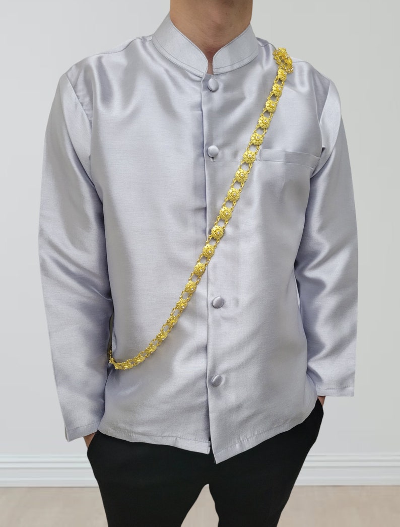 May include: A silver long-sleeved shirt with a mandarin collar and a gold chain with decorative links. The shirt has five buttons down the front.