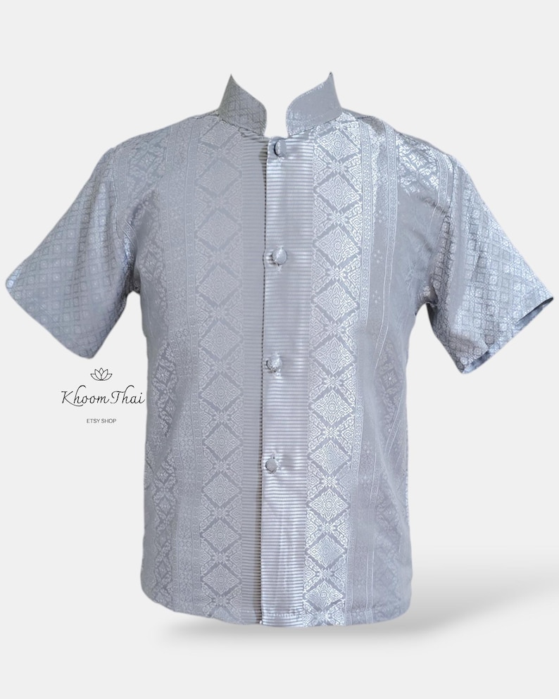 May include: A silver short-sleeved shirt with a mandarin collar and a button-up front. The shirt has a geometric pattern and a vertical stripe down the centre.