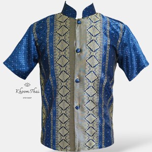 May include: A blue and gold short-sleeved shirt with a mandarin collar and a button-up front. The shirt features a traditional Thai pattern.
