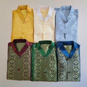May include: Six patterned shirts with mandarin collars and button fastenings. The shirts are in a variety of colours, including yellow, light blue, maroon, green, and blue.