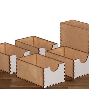 Puede incluir: Cinco cajas de madera con interiores blancos. Las cajas est&aacute;n apiladas en forma escalonada. Las cajas son todas del mismo tama&ntilde;o y forma, y tienen un dise&ntilde;o simple y moderno.