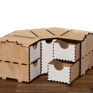 Puede incluir: Un organizador de esquina de madera con cinco cajones. Los cajones est&aacute;n hechos de madera contrachapada y tienen un acabado blanco. El organizador est&aacute; hecho de madera natural y tiene un acabado marr&oacute;n claro.