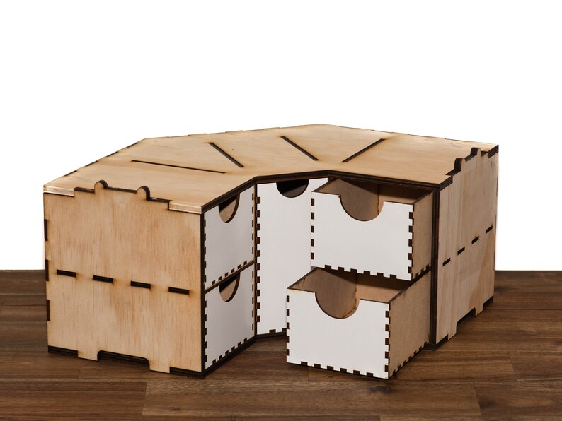 Puede incluir: Un organizador de esquina de madera con cinco cajones. Los cajones est&aacute;n hechos de madera contrachapada y tienen un acabado blanco. El organizador est&aacute; hecho de madera natural y tiene un acabado marr&oacute;n claro.