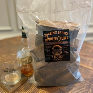 May include: A bag of 7 pounds of bourbon barrel smoker chunks, made from 100% American white oak wood. The bag is labeled "Bourbon Barrel Smoker Chunks" and "The Whiskey Workshop". The label also states that the chunks are great for smoking beef, pork, and poultry, and can also be used with seafood, lamb, and wild game.