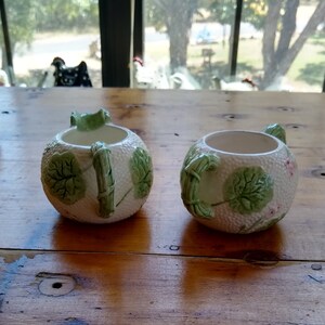 May include: Two white ceramic sugar and creamer set with green leaf and bamboo designs.