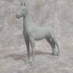 May include: A gray, plastic horse figurine in a standing pose. The horse has a slender neck, a detailed mane, and is posed with its legs slightly apart. The figurine is a solid color and appears to be a model or toy.