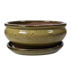 以下が含まれることがあります： 緑色の釉薬をかけたセラミック製のプランターと、それに合う受け皿。プランターはひび割れた釉薬の仕上げになっています。