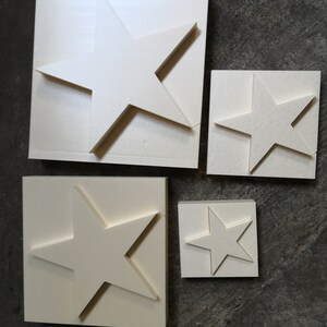 May include: Four white foam star shapes of varying sizes. The stars are cut out of the foam and are ready to be used for crafts or decorations.