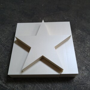 May include: A white foam star shape, cut out from a larger square piece of foam.