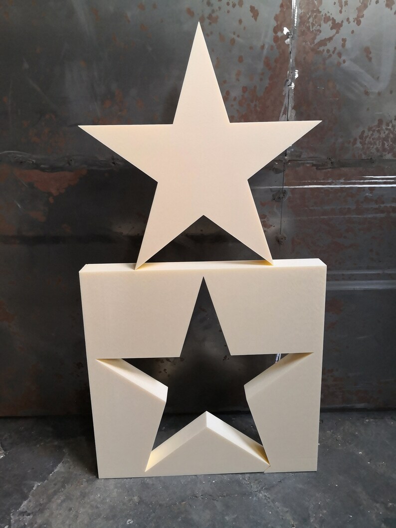May include: Two white foam stars, one large and one small. The large star is on top of the small star, which is cut out of a square piece of foam.
