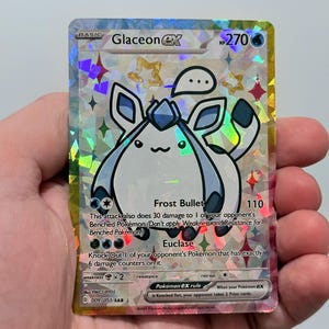 May include: A holographic Glaceon EX Pokémon trading card. The card features a cartoon Glaceon character with blue and white coloring. The card has the text "Glaceon EX" and "Frost Bullet" printed on it.