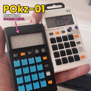 May include: Two portable electronic synthesizers, one black with blue buttons and one white with black buttons. The black unit features a screen bezel, labeled POKZ-01 NOW WITH SCREEN BEZEL. Both devices have a grid of square buttons, small circular knobs, and rectangular function keys.