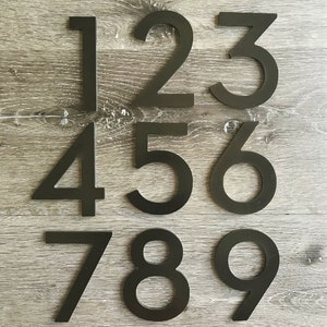 May include: Black metal house numbers 1 through 9. The numbers are arranged in three rows, with three numbers in each row.
