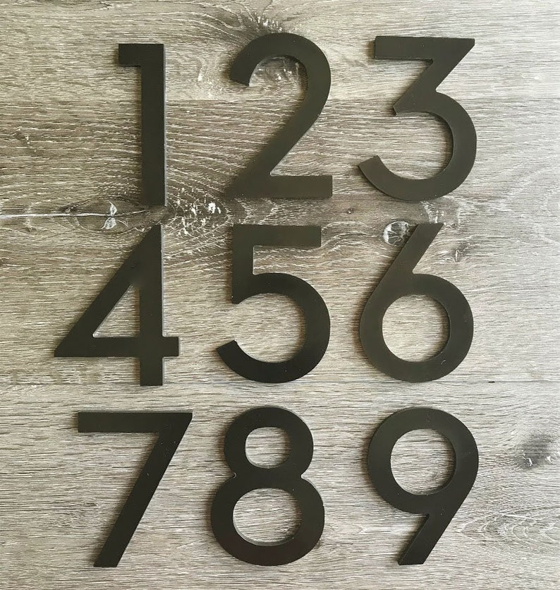 May include: Black metal house numbers 1 through 9. The numbers are arranged in three rows, with three numbers in each row.