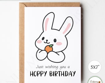 Op de afbeelding: Printbare kaart van 12,7 x 17,8 cm met een wit konijn dat een sinaasappel vasthoudt. De kaart zegt "Just wishing you a Hoppy Birthday".