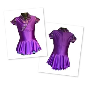 May include: Purple figure skating dress with short sleeves and a ruffled skirt. The bodice has a black and white patterned design.