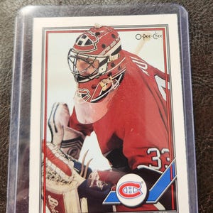 May include: A hockey trading card featuring Patrick Roy of the Montreal Canadiens. The card shows Roy in his red and white goalie gear, with the team logo and his number 33 visible. The card is in a protective sleeve.