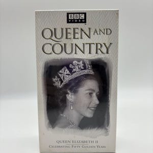 May include: A VHS tape titled "Queen and Country" featuring a black and white image of Queen Elizabeth II wearing a crown and jewelry. The BBC Video logo is at the top. The text reads "Celebrating Fifty Golden Years."