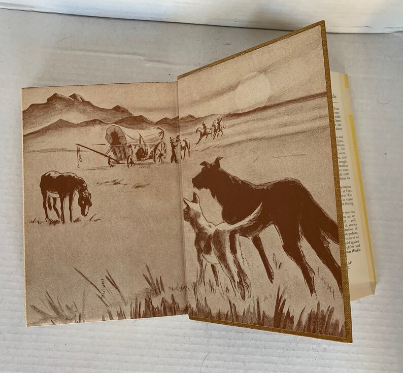 May include: A sepia-toned illustration of a covered wagon travelling across a vast, open plain. Two dogs, one large and one small, are in the foreground, looking towards the wagon. The sun is shining brightly in the sky.