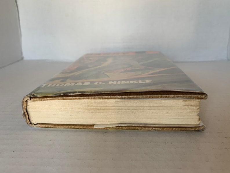 May include: A tan hardback book with the title "The Story of the American People" and the author's name "Thomas C. Hinkle" on the spine.