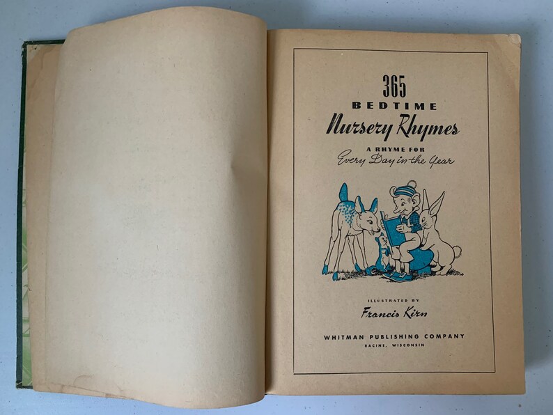 Puede incluir: Un libro vintage titulado "365 Canciones de cuna para dormir" con una rima para cada d&iacute;a del a&ntilde;o. La portada presenta una ilustraci&oacute;n de un ni&ntilde;o leyendo a un ciervo y un conejo.