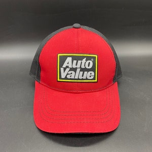 Könnte beinhalten: Rote und schwarze Mesh-Baseballkappe mit einem gelben quadratischen Patch, auf dem "Auto Value" in weißen Buchstaben steht.