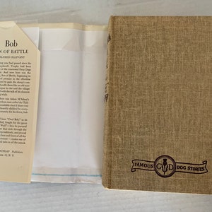May include: A brown book with the title "Bob, Son of Battle" by Alfred Ollivant. The book is part of a series called "Famous GWD Dog Stories".