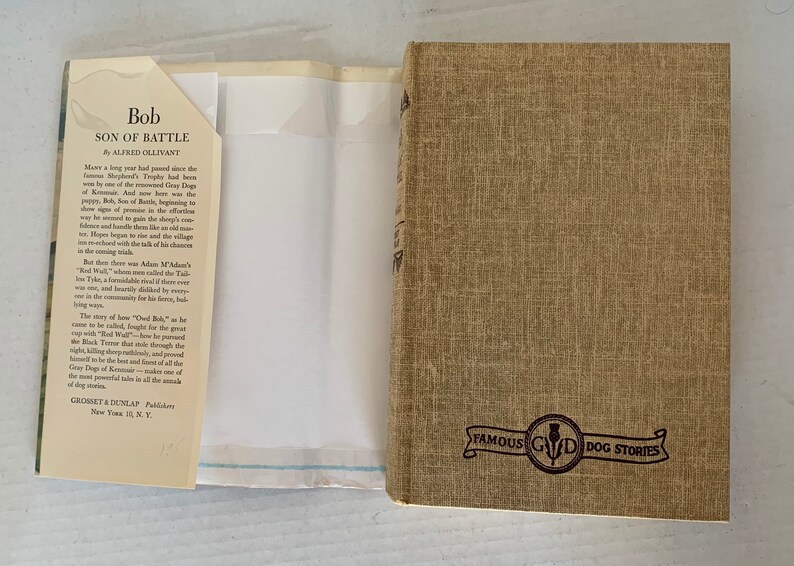 May include: A brown book with the title "Bob, Son of Battle" by Alfred Ollivant. The book is part of a series called "Famous GWD Dog Stories".