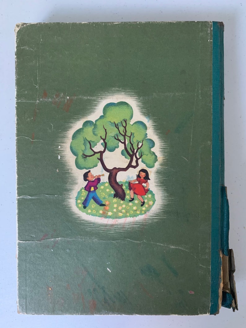 Puede incluir: Una cubierta de libro verde con una ilustraci&oacute;n vintage de un ni&ntilde;o y una ni&ntilde;a jugando bajo un &aacute;rbol. El ni&ntilde;o est&aacute; tocando un cuerno y la ni&ntilde;a est&aacute; sosteniendo una flor.