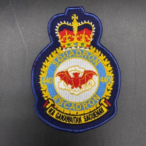 Op de afbeelding: Een blauwe en gele geborduurde patch met een rode vleermuis en de tekst "440 Squadron Tu Ganawai'tak Sacuenay".