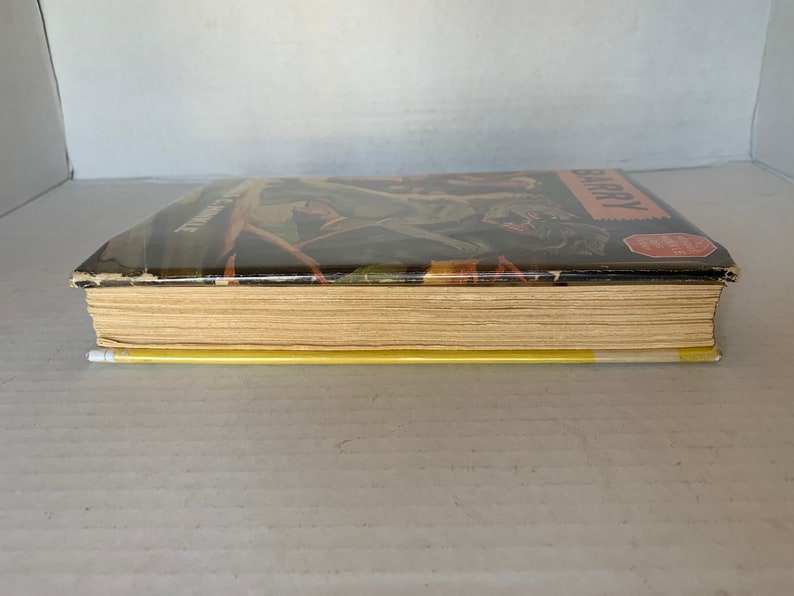 May include: A vintage hardback book with a yellow spine and a brown cover featuring a black and white illustration of a jungle scene with the text "The Jungle Book" and "HARRY" on the cover.