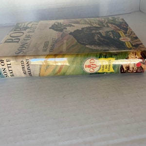 May include: A vintage book cover with a brown and white dog on the front. The title is "Bob, Son of Battle" by Alfred Ollivant. The book is part of the "Famous Dog Stories" series.