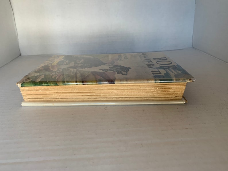 May include: A vintage hardcover book with a green, brown, and white illustrated cover. The title of the book is "BOB, Son of Battle".