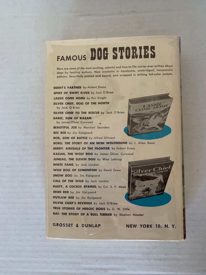 May include: A book cover with a blue background and the title "Famous Dog Stories". The cover features illustrations of dogs from various breeds, including a wolf, a terrier, and a hound. The book is published by Grosset & Dunlap.