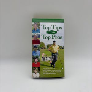 Puede incluir: Una caja rectangular con el título "Top Tips from Top Pros" y la palabra "MEDICUS" en una fuente estilizada. La caja presenta imágenes de golfistas y enumera nombres como Mark O'Meara y Bruce Fleisher.