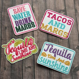 May include: Four embroidered patches with white backgrounds and colorful text. The patches read: "Save Water Drink Margs", "Tacos and Margs", "Tequila Lime and Sunshine", and "Tequila Lime And Sunshine".