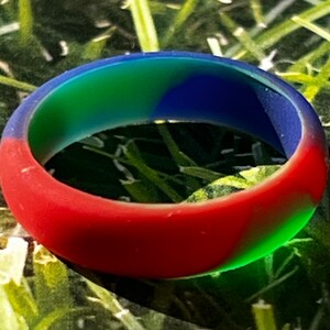 May include: A red, green, and blue silicone ring. The ring is a solid color with a marbled effect.