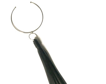 May include: A silver choker necklace with a black leather tassel hanging from it.