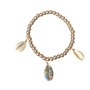 May include: A gold beaded bracelet with three shell charms. One shell is plain white, one is white with a blue and green pattern, and the other is white with a brown and gold pattern.