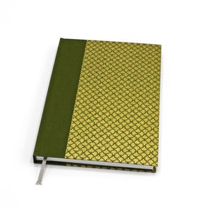 May include: A hardback journal with a green spine and a gold and green patterned cover. The journal has a silver ribbon bookmark. The cover design features a repeating floral pattern. The journal is closed and angled slightly.