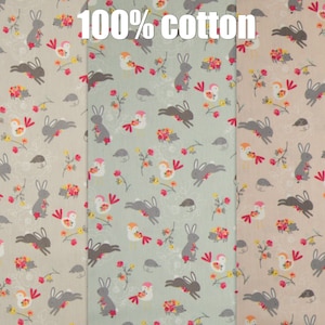 Op de afbeelding: Drie stofstalen met een herhalend patroon van konijnen, vogels en bloemen. De stof is 100% katoen. De stalen zijn beige, lichtgroen en lichtbruin.